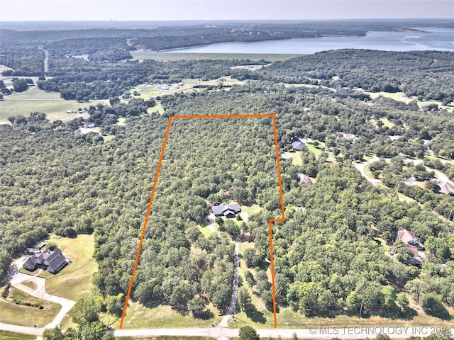 drone / aerial view with a water view and a wooded view