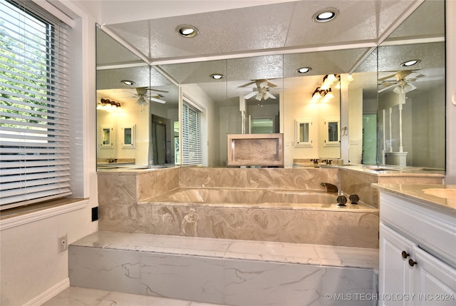 bathroom with toilet, vanity, tiled bath, and a textured ceiling