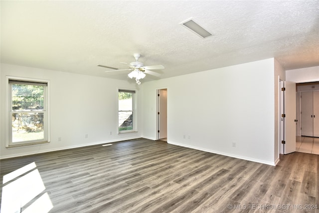 unfurnished room with wood-type flooring, ceiling fan, and a textured ceiling