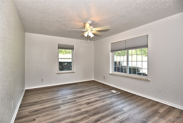 spare room with ceiling fan, dark hardwood / wood-style floors, and a textured ceiling