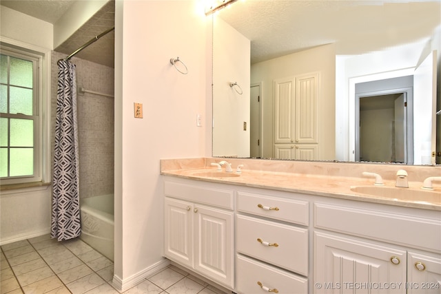 bathroom with shower / tub combo with curtain, vanity, a textured ceiling, and tile patterned floors