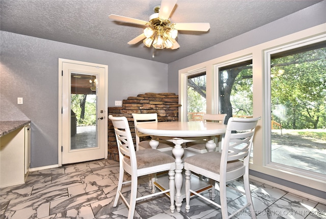 dining space with a textured ceiling and ceiling fan