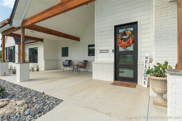 view of exterior entry featuring brick siding