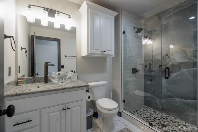 bathroom featuring tile patterned flooring, vanity, toilet, and a shower with door