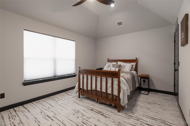 bedroom featuring lofted ceiling, ceiling fan, visible vents, and baseboards