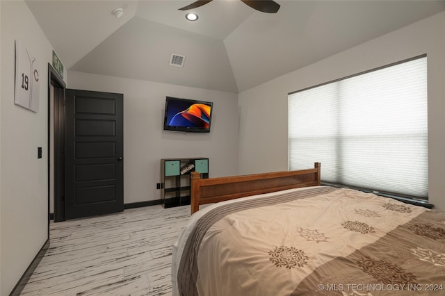 bedroom featuring ceiling fan, light wood-style flooring, visible vents, baseboards, and vaulted ceiling