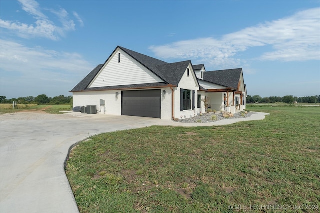 view of home's exterior featuring a garage, a lawn, concrete driveway, central AC, and brick siding