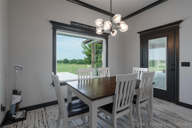 dining room with crown molding, light wood-style flooring, and baseboards