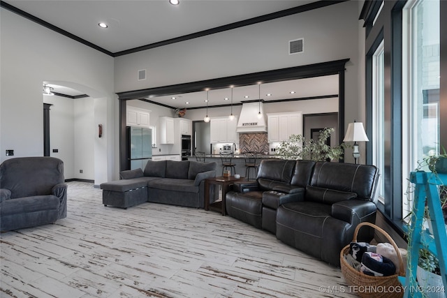 living room with arched walkways, crown molding, recessed lighting, visible vents, and baseboards