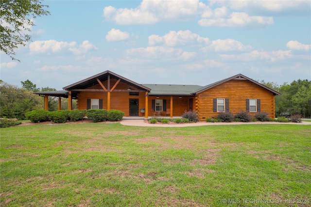 cabin featuring a front lawn