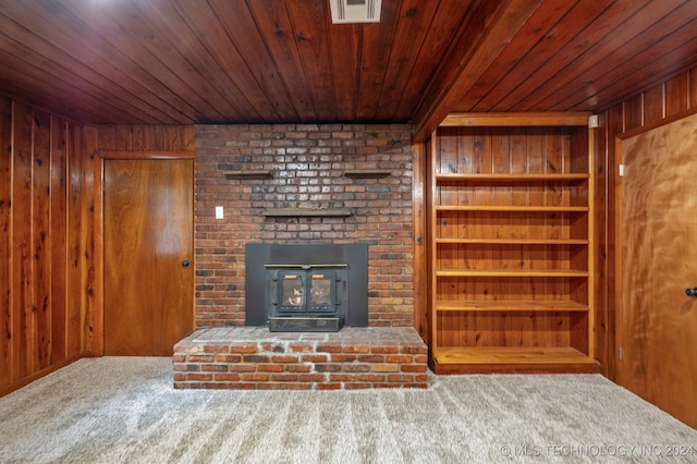 unfurnished living room with wood ceiling, a fireplace, carpet, and wooden walls