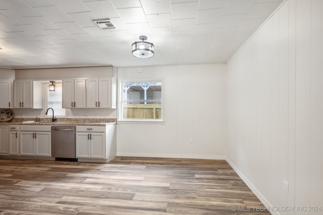 kitchen featuring sink, white cabinets, light hardwood / wood-style floors, and stainless steel dishwasher