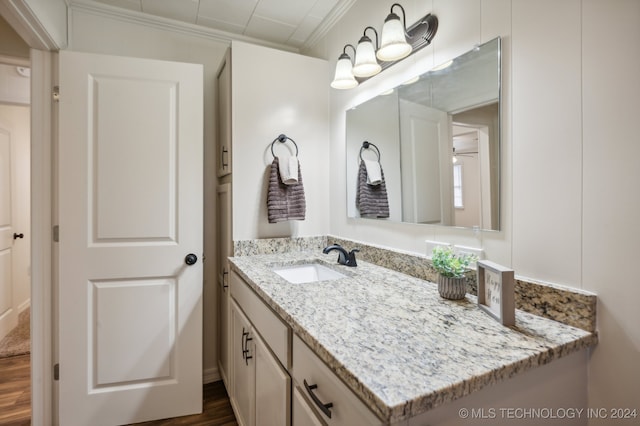 bathroom with ornamental molding, vanity, and hardwood / wood-style flooring