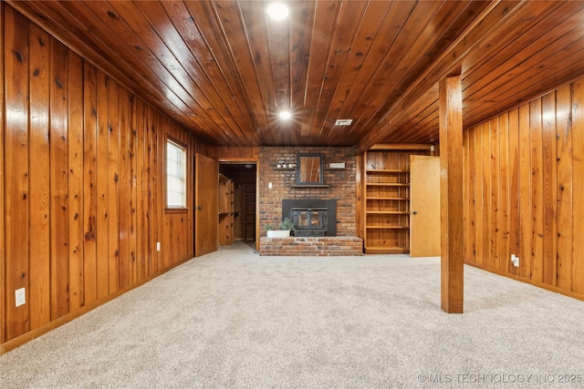 unfurnished living room with carpet, wood walls, and wood ceiling