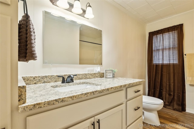 full bathroom with wood finished floors, vanity, curtained shower, toilet, and ornamental molding
