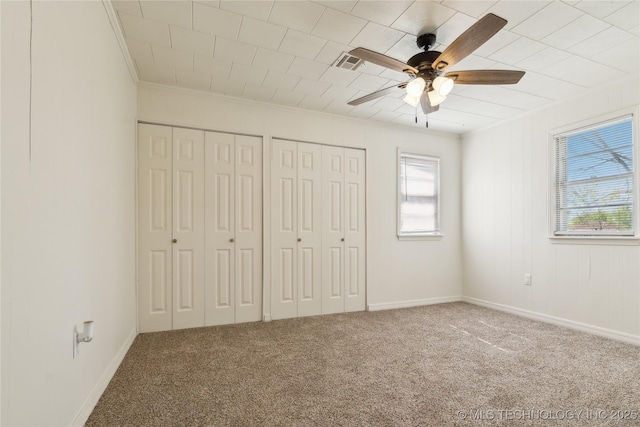 unfurnished bedroom featuring carpet, ornamental molding, and multiple windows