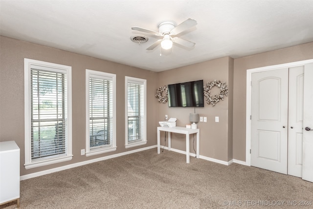 unfurnished bedroom featuring a closet, ceiling fan, and carpet