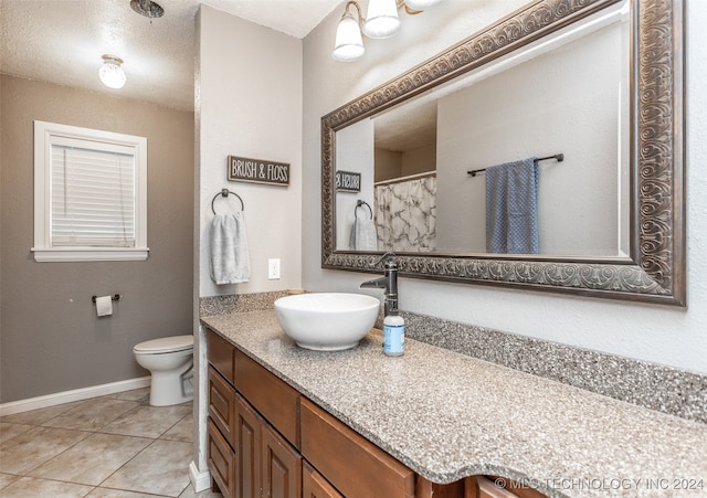 bathroom with tile patterned floors, toilet, a textured ceiling, and vanity