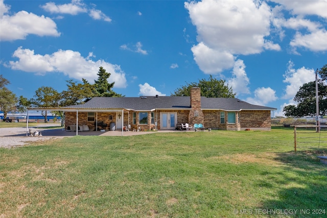 back of house with a patio, a carport, and a lawn