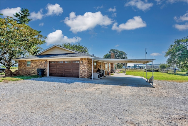 view of front facade with a garage, a carport, and a front yard