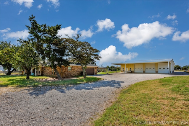 single story home featuring an outdoor structure, a garage, and a front lawn