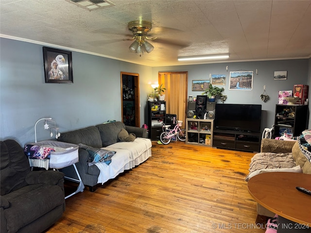 living room with ceiling fan, crown molding, and hardwood / wood-style floors