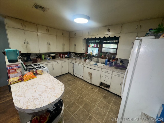 kitchen featuring sink, white appliances, white cabinetry, and backsplash