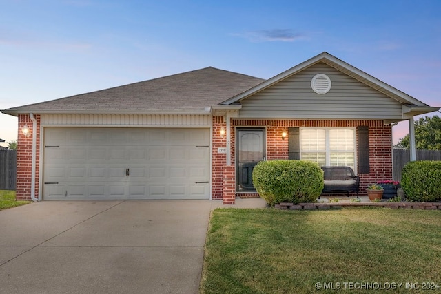 single story home with a garage and a yard