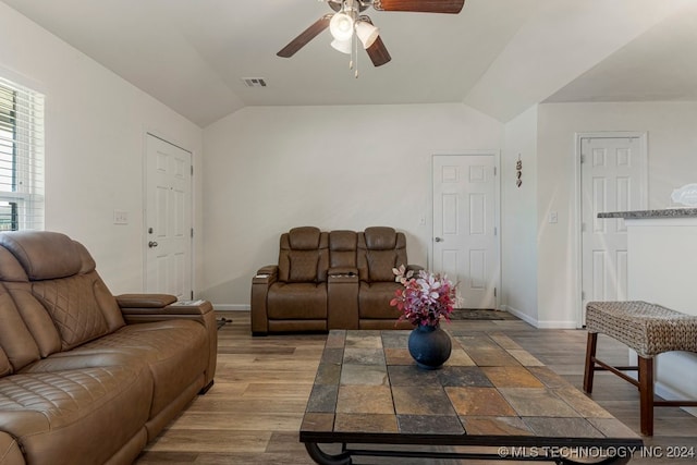 living room featuring ceiling fan, vaulted ceiling, and light hardwood / wood-style floors