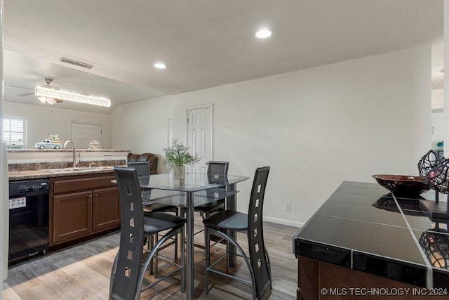 dining area featuring hardwood / wood-style floors, sink, and ceiling fan