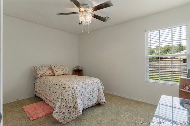 carpeted bedroom featuring ceiling fan and multiple windows