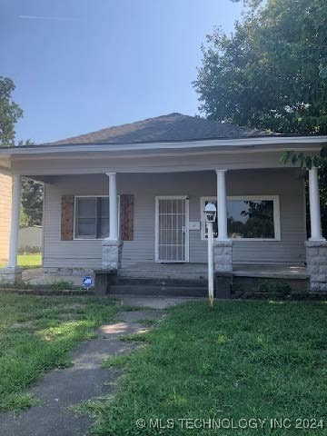 view of front of house featuring covered porch and a front lawn