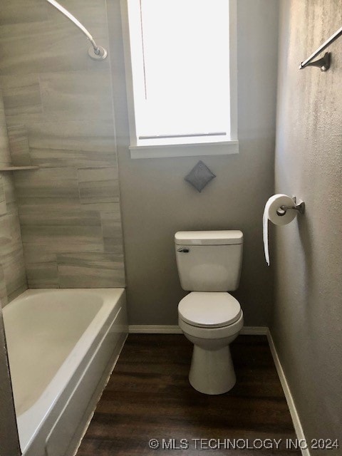 bathroom with hardwood / wood-style floors, toilet, and  shower combination