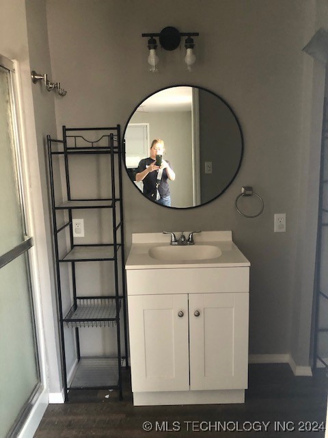 bathroom featuring a shower with shower door, vanity, and wood-type flooring