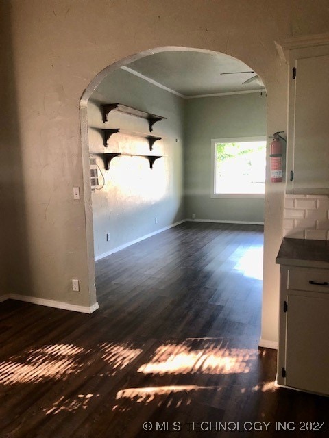 interior space featuring dark wood-type flooring and crown molding