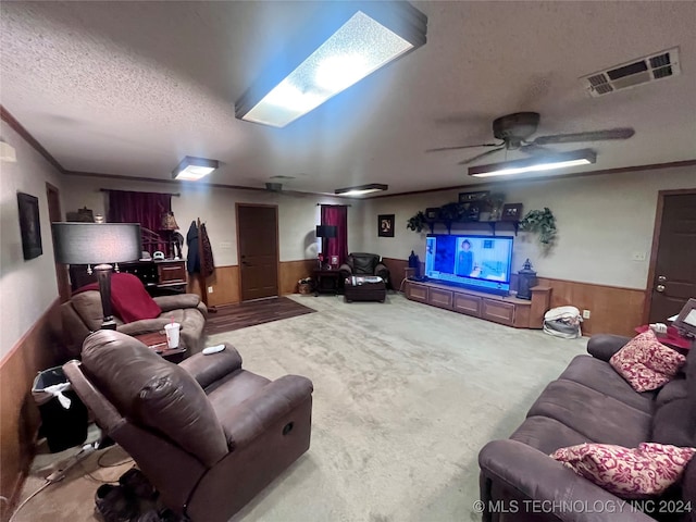 cinema featuring carpet floors, wooden walls, ornamental molding, a textured ceiling, and ceiling fan