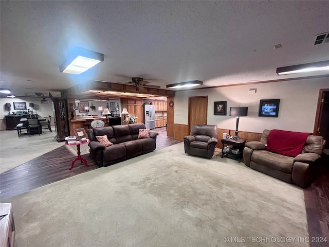 living room featuring a textured ceiling, carpet, and ceiling fan