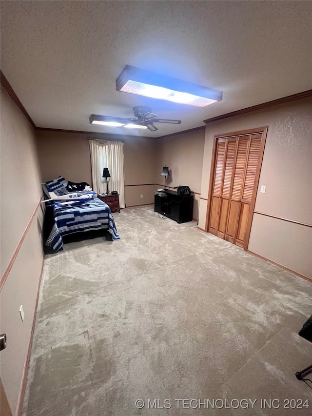 carpeted bedroom featuring ornamental molding, a closet, a textured ceiling, and ceiling fan