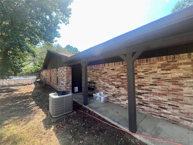 view of side of property with a patio area and central AC unit