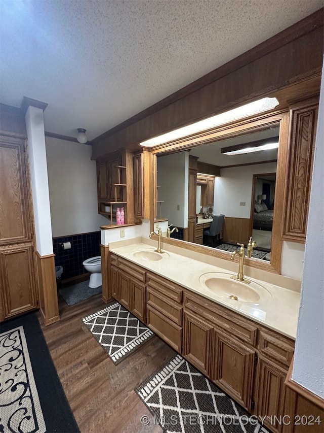 bathroom with toilet, a textured ceiling, vanity, and wood-type flooring