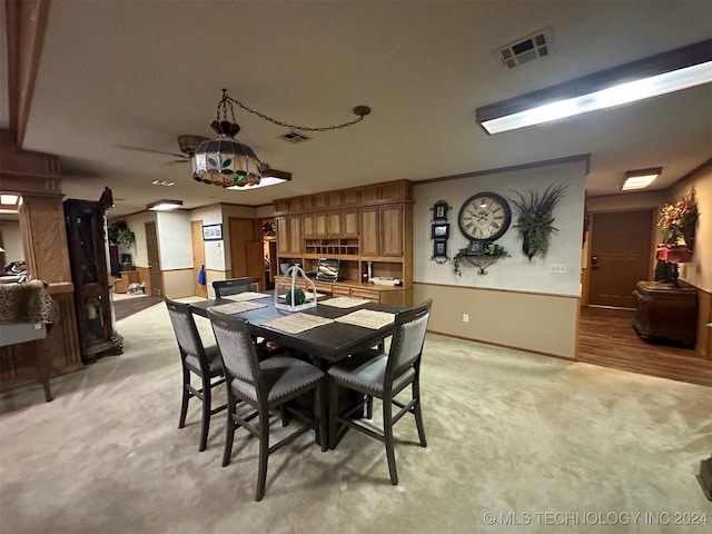 carpeted dining area with ceiling fan