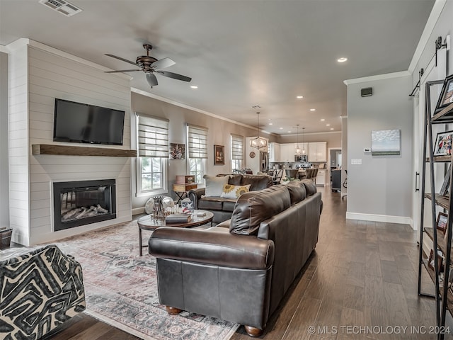 living room with ceiling fan, a fireplace, wood-type flooring, and ornamental molding