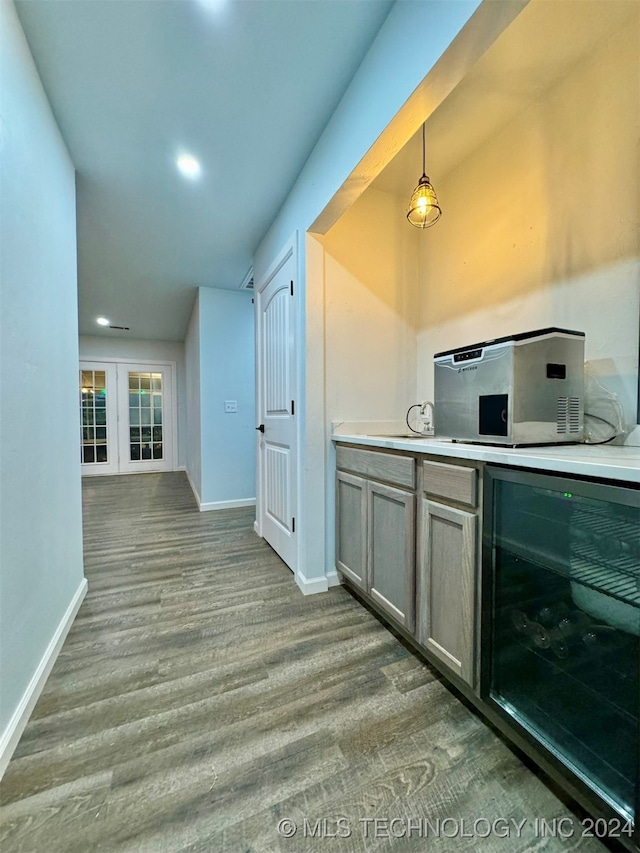 kitchen with beverage cooler, hanging light fixtures, and hardwood / wood-style flooring