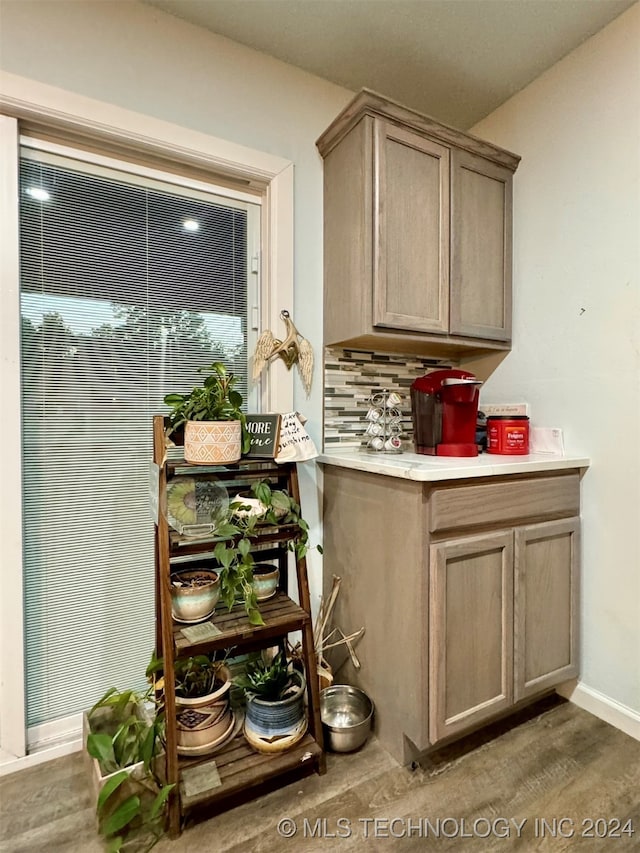 interior space with hardwood / wood-style floors, decorative backsplash, and light brown cabinetry