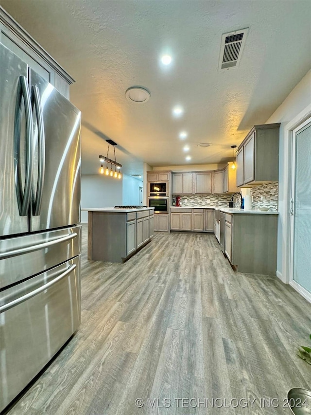 114399 Oak Rd, Eufaula, OK 74432 - kitchen featuring visible vents, gray cabinetry, light wood-type flooring, hanging light fixtures, and stainless steel appliances