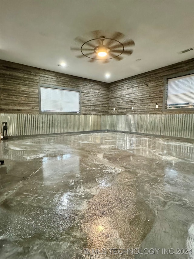 spare room with ceiling fan and concrete floors