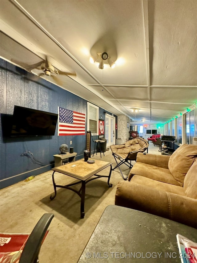 living room featuring ceiling fan and concrete flooring