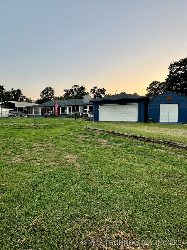 yard at dusk with an outdoor structure and a garage