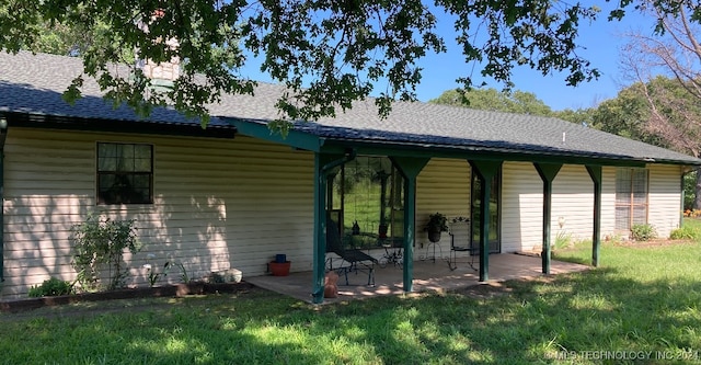 back of property featuring a patio area and a lawn