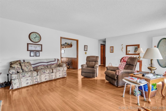 living room with a textured ceiling and light wood-type flooring